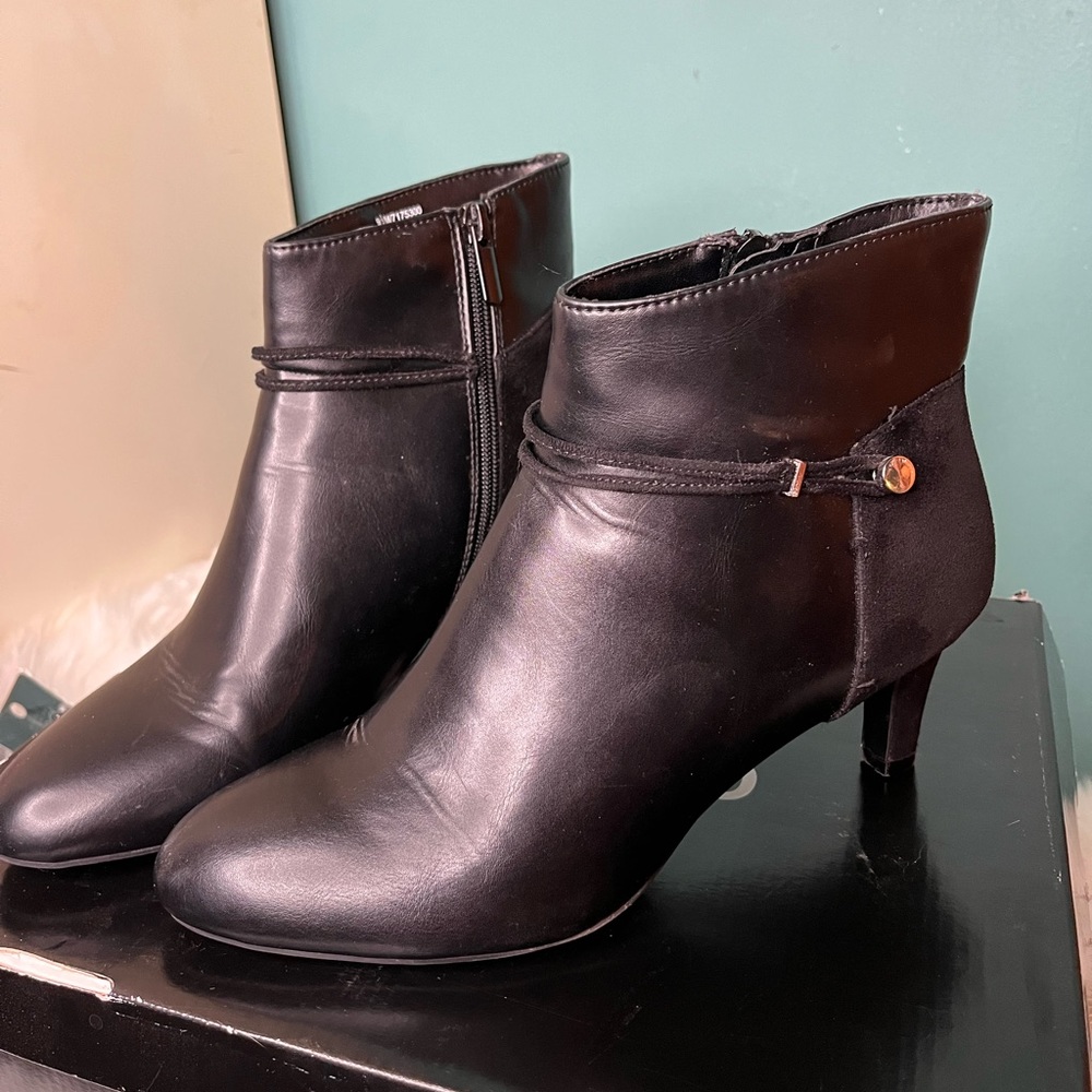 Black leather and suede booties with a silver accent button on the side.